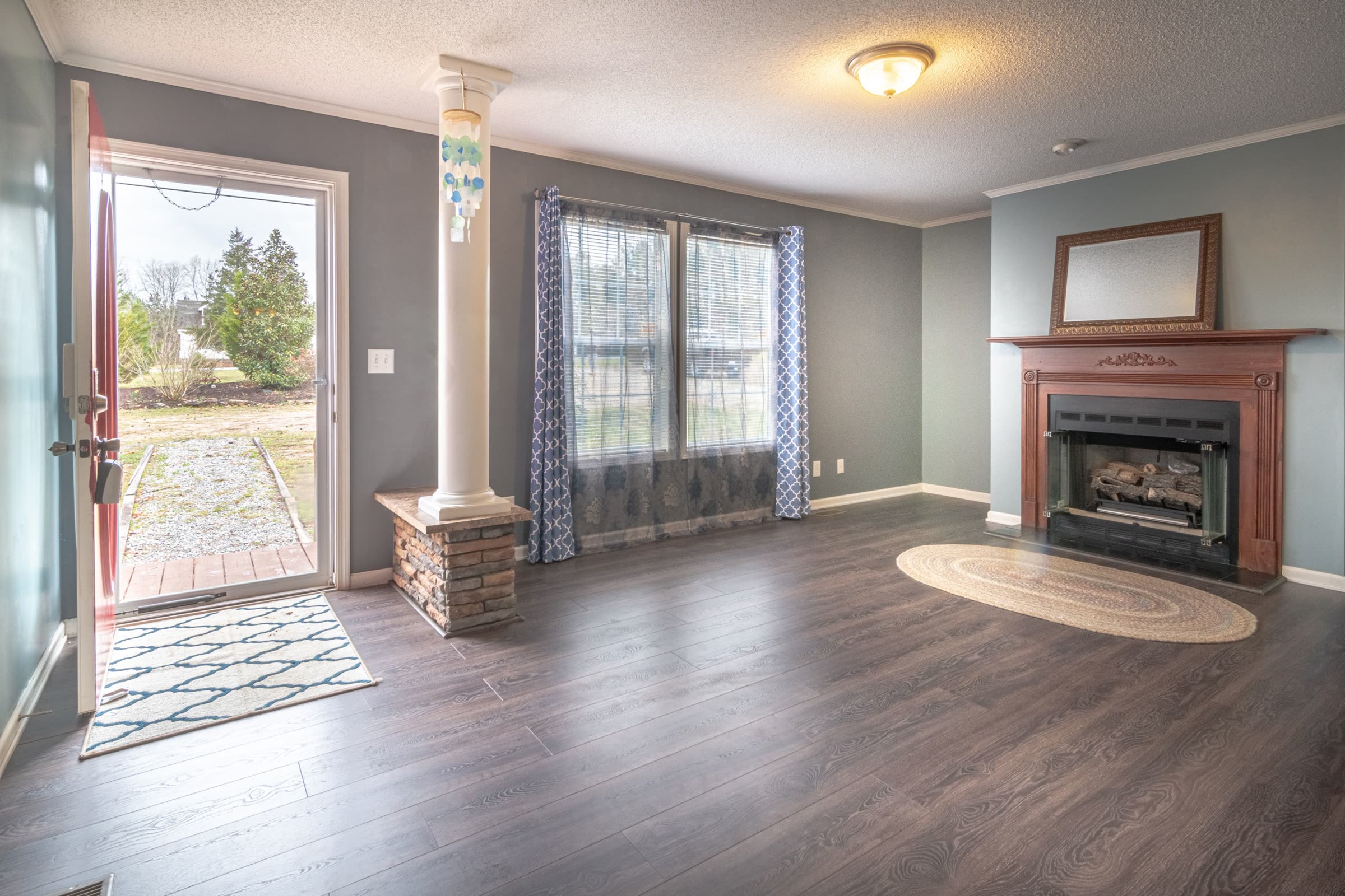 An empty, freshly presented living room with hardwood floors and a fireplace