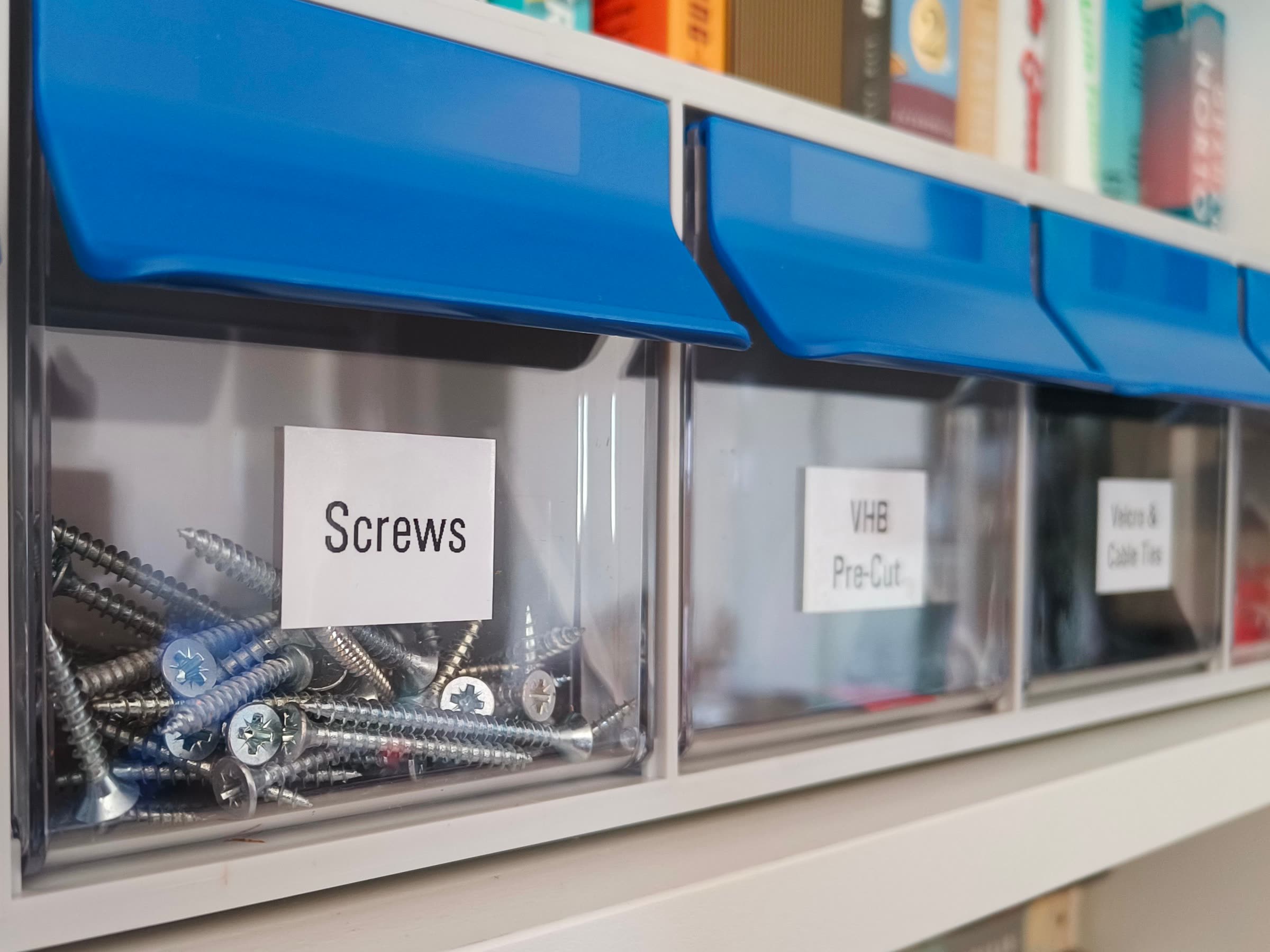 An organized garage storage wall with labeled bins and clear floor space