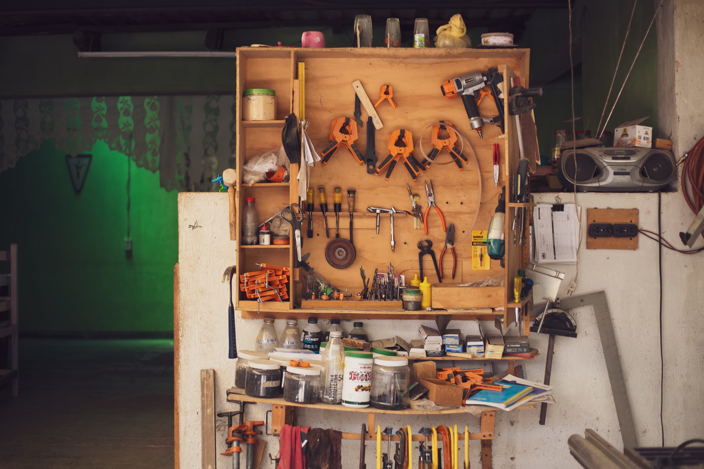 A cluttered garage workshop with tools and supplies competing for space